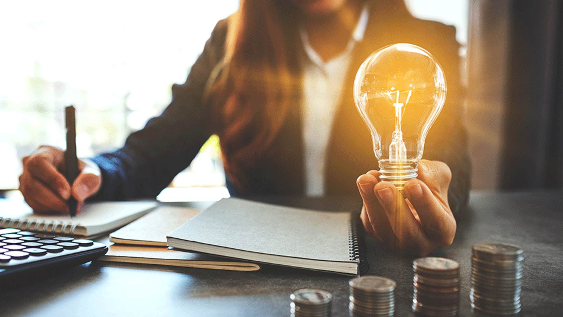 Frau hält leuchtende Glühbirne in der Hand
