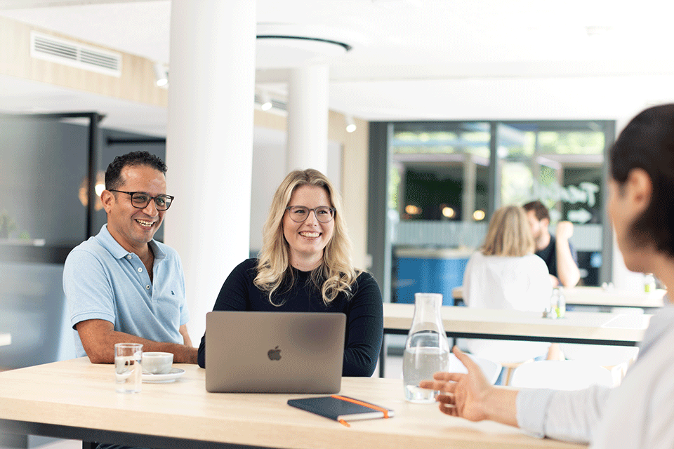 menschen auf freier fläche im büro mit Laptop