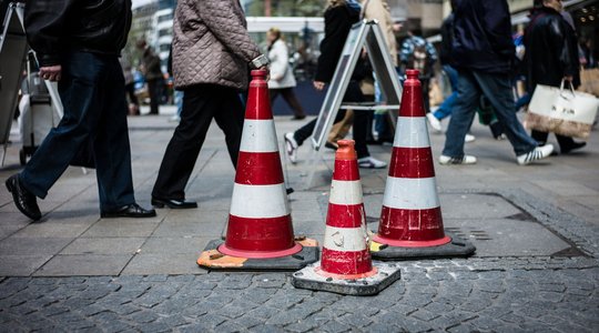 Pylonen auf dem Asphalt Pylonen stehen auf dem Asphalt im Hintergrund laufen Menschen vorbei