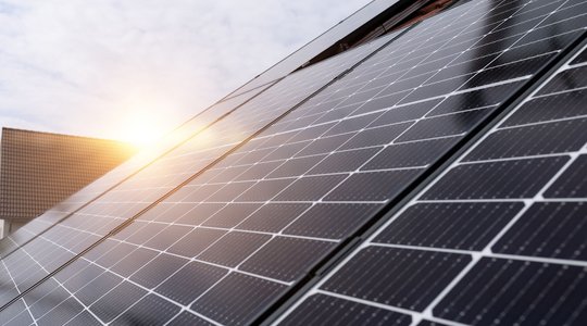 DEW21 Solarpanele Photovoltaikanlage mit der Sonne im Hintergrund