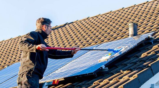 Reinigung der Solaranlage Mensch der Photovoltaikanlage reinigt